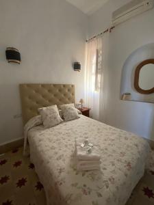 una camera da letto con un grande letto e un copriletto bianco di Tranvía Beach House a Chipiona