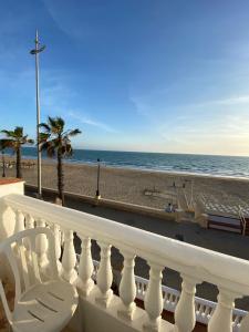 a beach scene with a balcony overlooking the ocean at Tranvía Beach House in Chipiona