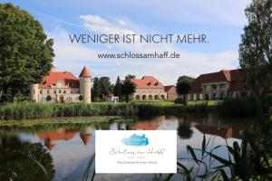 a sign in front of a building next to a river at Die Remise Condé RE-10 in Stolpe auf Usedom +1 photo