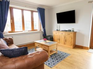 a living room with a couch and a flat screen tv at Aurora in Holyhead