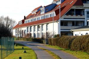 ein großes weißes Gebäude mit rotem Dach in der Unterkunft Der Landhof Weide in Stolpe auf Usedom