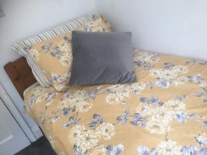 a bed with a pillow on top of it at Cricketers Cottage B&B in Kent