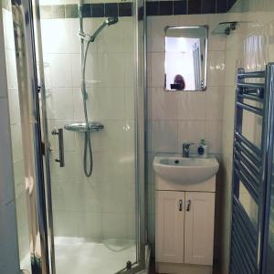 a bathroom with a shower and a sink at Cricketers Cottage B&B in Kent