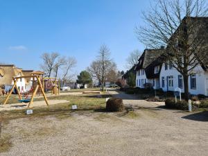a park with a playground and a swing set at Das Landhaus am Haff LHH B06 in Stolpe