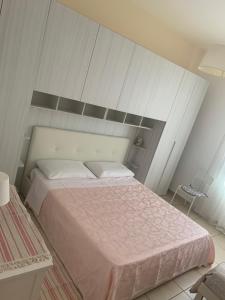a bedroom with a large bed with pink sheets at Residence Massilor in Gallipoli