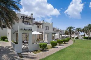 a large white house sitting in the middle of a grassy area at Radisson Blu Hotel & Resort, Al Ain in Al Ain
