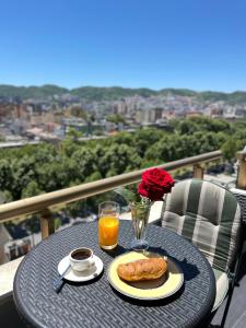 uma mesa com um prato de comida e um copo de sumo de laranja em By Best Apartments em Tirana