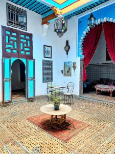a room with a table and a couch and a table at Riad Khmisa in Tetouan