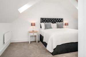 a bedroom with a large bed and a side table at Citystay - Finch House in Cambridge