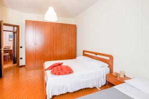 een slaapkamer met 2 bedden en een houten hoofdeinde bij Montescudo Centro Apt a 5 min da San Marino x3 in Montescudo