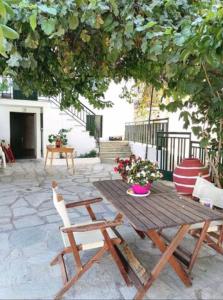 a wooden picnic table and chairs under a tree at Maria's traditional house in Trikeri