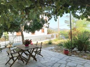 a picnic table and two benches on a patio at Maria's traditional house in Trikeri +8 photos