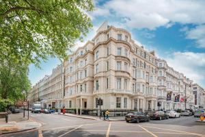 ein großes weißes Gebäude, vor dem Autos parkten in der Unterkunft Ashburn Hotel in London