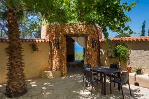 a patio with a table and chairs under a tree at Villa Tres Yucas - La Cabaña in San Antonio