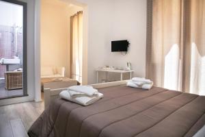 1 dormitorio con 1 cama con toallas en B&B Barone Sieri Pepoli, en Trapani