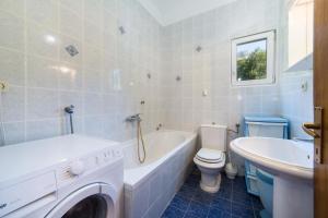 ein Badezimmer mit einer Badewanne, einem WC und einem Waschbecken in der Unterkunft Apartments Slavena in Gradac