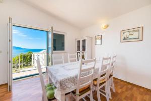 una sala da pranzo con tavolo e vista sull'oceano di Apartments Slavena a Gradac (Grado)