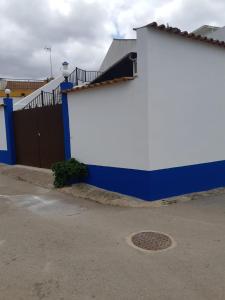 AlvaladeMansão Alentejana AL的一座带门和栅栏的蓝色和白色建筑