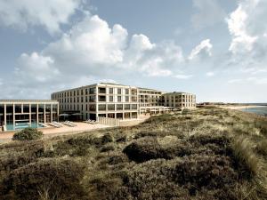 a building on the beach next to the ocean at A-ROSA Sylt in List