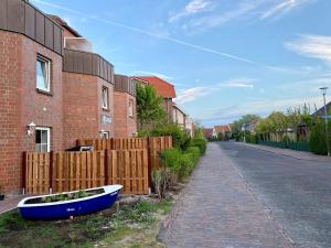 a blue boat sitting on the side of a house at Ferienwohnung Gustav - Moderne Maisonette-Wohnung mit Terrasse in Wangerooge