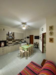 een woonkamer met een tafel en een keuken bij Casa Nonna Bianca- appartamento pratico a pochi minuti da Napoli in Casalnuovo di Napoli