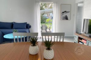 a living room with a table with two chairs and a tv at Breezy Blue on Bribie in Bongaree