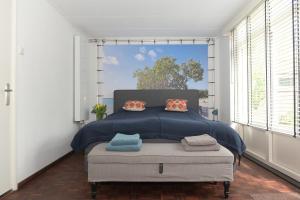 a bedroom with a bed and a large window at AaBenB appartement in Tilburg