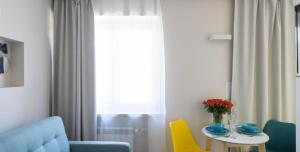 a living room with a blue chair and a table at Apartamenty In Sea Bay Chałupy in Chałupy