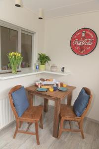 a wooden table with two chairs and a table with food on it at AaBenB appartement in Tilburg