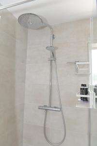 y baño con ducha con cabezal de ducha. en AaBenB appartement en Tilburg