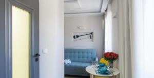 a living room with a blue couch and a table at Apartamenty In Sea Bay Chałupy in Chałupy