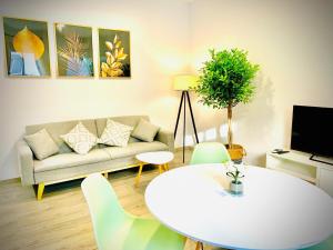 a living room with a white table and a couch at Apartamentos Villas Romanas in Mérida