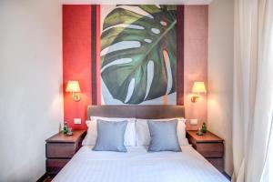 a bedroom with a bed with a painting on the wall at Milhouse Suites Duomo in Milan