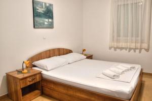 a bedroom with a large bed with white sheets at Apartmani Obala in Promajna +21 photos