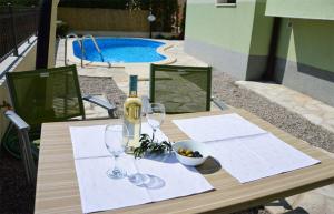 a table with glasses and a bottle of wine on it at Apartmani Obala in Promajna