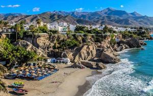 plaża z kilkoma krzesłami i oceanem w obiekcie MAGNOLIO APARTMENT CALACEITE w mieście Torrox Costa