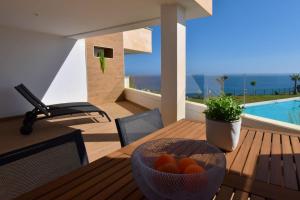 drewniany stół z miską pomarańczy w obiekcie MAGNOLIO APARTMENT CALACEITE w mieście Torrox Costa