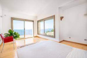 een slaapkamer met een wit bed en een rode stoel bij Herce Property - Minimalist & Mediterranean in Llucmajor