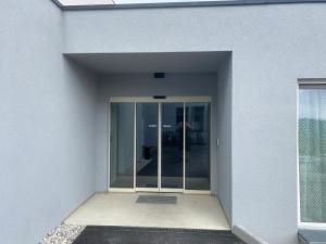 an entrance to a white building with a glass door at Campus Ferlach in Ferlach
