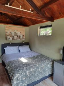 een slaapkamer met een bed in een kamer met houten plafonds bij Eikelhof in Berkel-Enschot