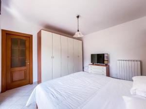 1 Schlafzimmer mit einem weißen Bett und einem TV in der Unterkunft MYHOUSE INN TORINO 1 - Affitti Brevi Italia in Collegno