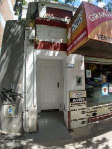 a gas station with a white door and a garage at Mio Amore Tigre - C in Tigre