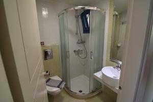 a bathroom with a shower and a toilet and a sink at Horizon Beach Hotel in Plakias