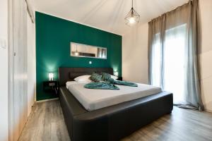 1 dormitorio con 1 cama con pared verde en Luxurious Villa Natali, en Pridraga