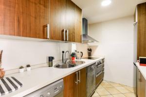 a kitchen with wooden cabinets and a sink at Hacienda del Álamo Fuente Alamo 2 Bedroom Penthouse Golf Resort in Fuente Alamo