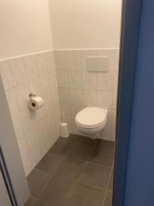a bathroom with a toilet and a toilet paper dispenser at Campus Ferlach in Ferlach