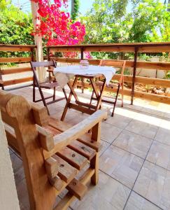 a patio with a table and chairs and flowers at SteMa Seaside Apartments in Gouves