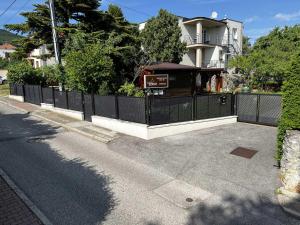 une clôture avec un panneau devant une maison dans l'établissement Ubytovanie Zobor, à Nitra