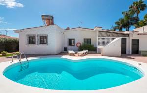 a swimming pool in front of a house at Bungalow Yumbo in Playa del Ingles
