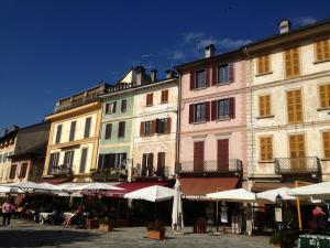 un grupo de edificios con sombrillas delante de ellos en Casa Vacanza Piazza, en Orta San Giulio